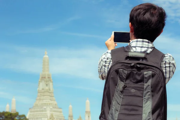 Turistas segurando um telefone celular para tirar fotos você mesmo sorrir — Fotografia de Stock
