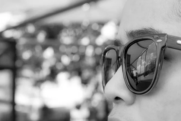 Black and white face woman wearing brown sunglasses are looking
