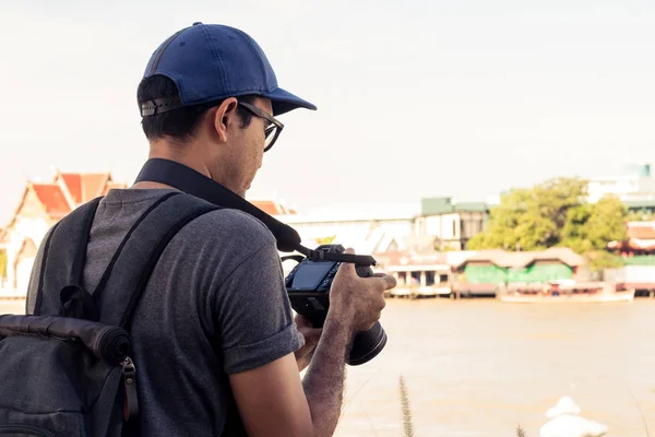 Hombres que llevan mochila y sostienen una cámara . — Foto de Stock