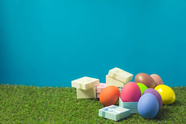 Huevos de Pascua y caja de regalo en la hierba verde . — Foto de Stock