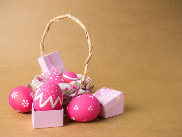 Easter eggs in a basket weave wood on the left corner on a brown — Stock Photo, Image