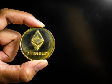 El altın ethereum sikke tutuyor.