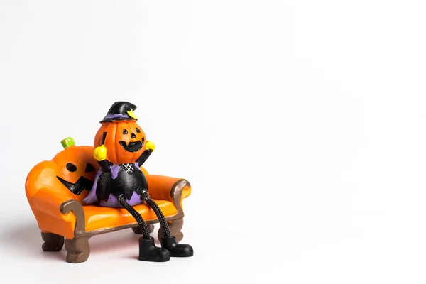 Zauberpuppe Halloween-Kürbis sitzt auf einem Sofa in Orange und Co — Stockfoto