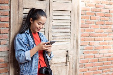 Bir ceket, kot pantolon ve turuncu gömlek giyen kız bir karşı duran