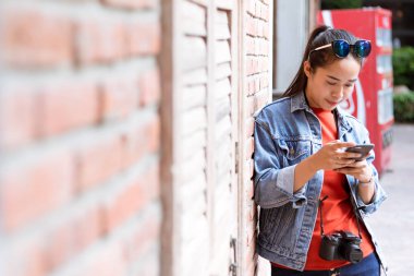 Başında güneş gözlüğü olan, ceket, kot pantolon ve orang giyen kadın