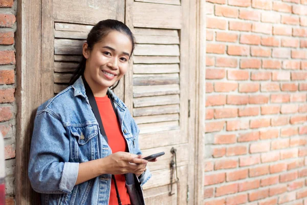 Bir ceket, kot pantolon ve turuncu gömlek giyen kız bir karşı duran