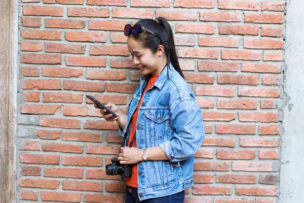 Mujer con gafas de sol en la cabeza, con chaqueta, jeans y orang — Foto de Stock