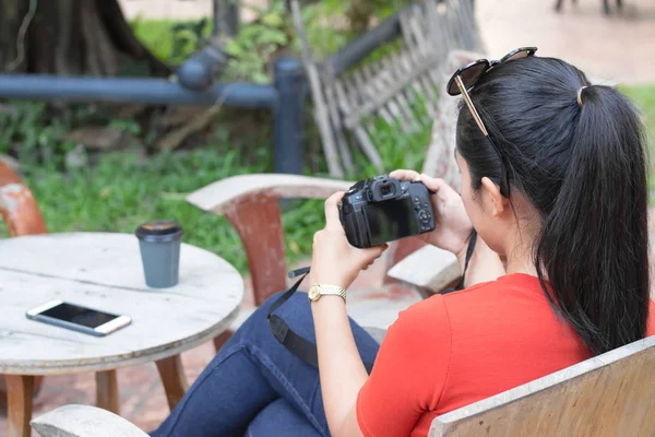 女性はカメラを再生し、携帯電話、コーヒーカップiを持っています — ストック写真