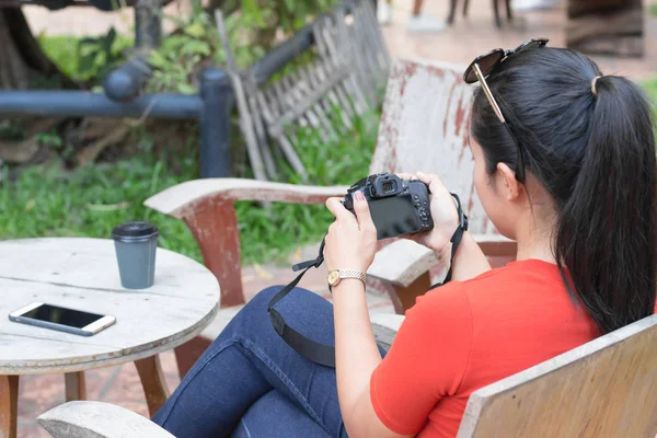 女性はカメラを再生し、携帯電話、コーヒーカップiを持っています — ストック写真