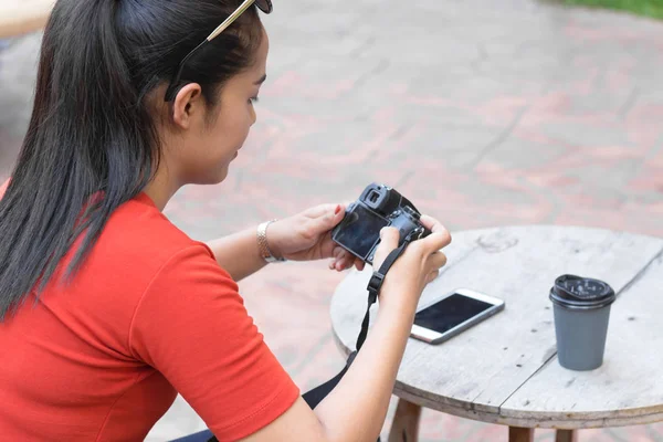 女性はカメラを再生し、携帯電話、コーヒーカップiを持っています — ストック写真