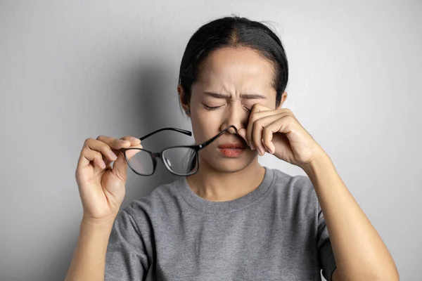 Women hold glasses and suffer from eye pain.