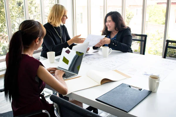 A női alkalmazottak munkát ajánlanak a főnöknek a megbeszélésen. — Stock Fotó