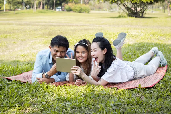 Ouders en kinderen spelen de tablet op de mat. — Stockfoto