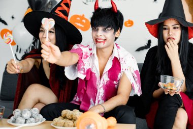 Genç Asyalı kostümlü cadı, büyücü, Cadılar Bayramı temalı partiyi evde kutluyoruz. Gençler ve Taylandlılar Cadılar Bayramı partisini gülümseyerek kutluyor. Evde Cadılar Bayramı partisi kavramı.