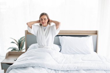 Sabah uyandıktan sonra esneme hareketleri yapan bir kadın. Güzel kadınlar ferahlatıcı bir şekilde uyanır..