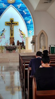 Kuta, Bali, Endonezya 'daki Santo Fransiskus Xaverius Kilisesi' nin sunağına bakan iki kişi, 1 Temmuz 2025 'te dua ederken diz çöker..