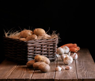 Patates sarımsaklı havuç, sebze, çiğ yiyecek sepeti, sade ahşap zemin.