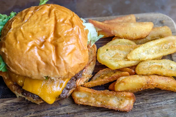 Burger i frytki na drewnianym stole — Zdjęcie stockowe