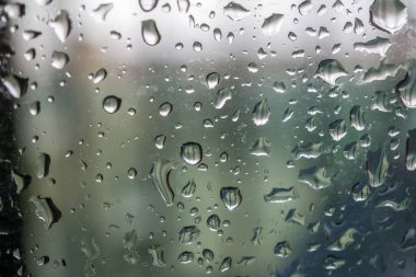 soyut arkaplan mavi tonlu yağmur damlaları olan bir pencere gösteriyor