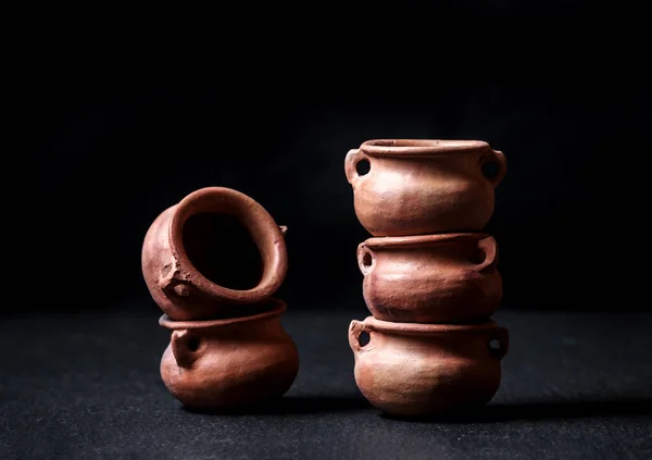 clay pots small mud vessel still life isolated on chiaroscuro black background