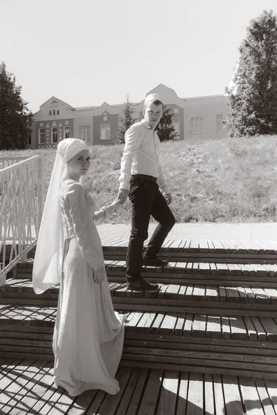 Couple young muslim man and woman on the summer field look to each other. Muslim tatar wedding. Selective focus