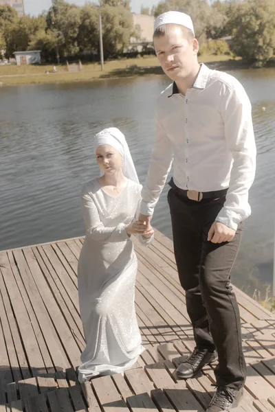 Couple young muslim man and woman on the summer field look to each other. Muslim tatar wedding. Selective focus