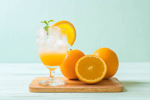 orange juice with soda on wood table