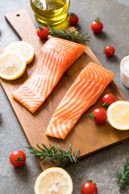 Limon domates Biberiye Biber ve tuz ahşap tahta üzerinde Çiğ somon fileto