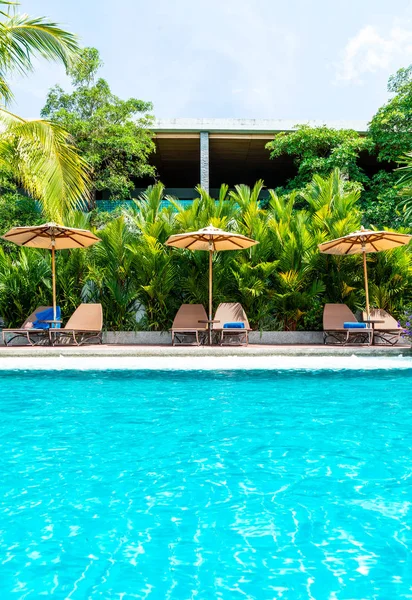 傘とホテルとリゾートの休日休暇の概念のスイミング プールの周りの椅子 — ストック写真