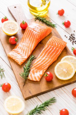 Limon domates Biberiye Biber ve tuz ahşap tahta üzerinde Çiğ somon fileto
