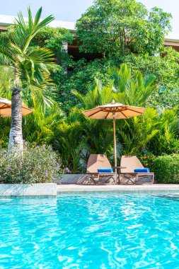 Güzel şemsiye ve sandalye yüzme havuzunda otel ve tatil - tatil tatil kavramı çevresinde