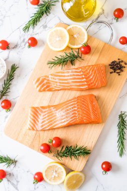 Limon domates Biberiye Biber ve tuz ahşap tahta üzerinde Çiğ somon fileto