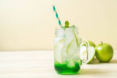 Yeşil elma soda ahşap masa üzerinde