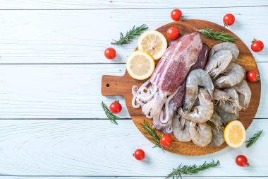 taze deniz ürünleri ham (karides, mürekkep) malzemelerle ahşap tahta üzerinde