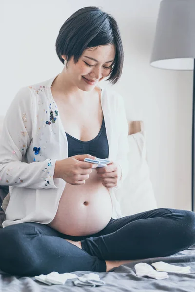 Joven Hermosa Mujer Embarazada Asiática Acostada Cama Elección Calcetines Bebé — Foto de Stock