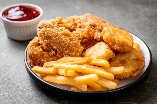 Kızarmış tavuk, patates kızartması ve nugget yemeği. Abur cubur ve sağlıksız yemek.