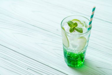 Yeşil elma soda ahşap masa üzerinde