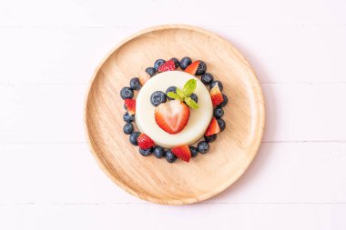 yoğurt puding plaka üzerinde bir yaban mersini ve taze çilek ile