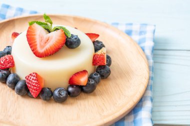yoğurt puding plaka üzerinde bir yaban mersini ve taze çilek ile