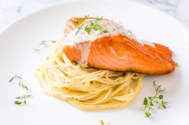 plaka üzerinde kızarmış som balığı spagetti