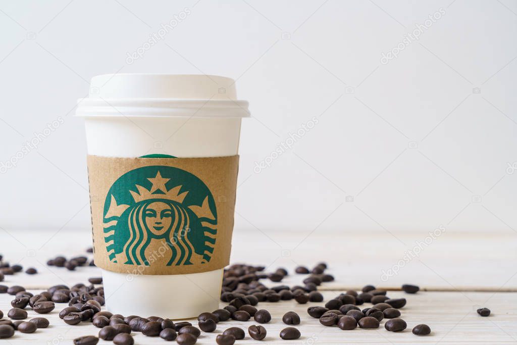 BANGKOK, THAILAND - JUN 5, 2018: White coffee cup with Starbucks logo on wood background. Starbucks is the world's largest coffee house with over 20,000 stores in 61 countries.