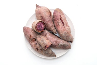 Beyaz arka planda izole edilmiş mor patatesler.