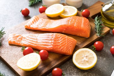 Limon domates Biberiye Biber ve tuz ahşap tahta üzerinde Çiğ somon fileto