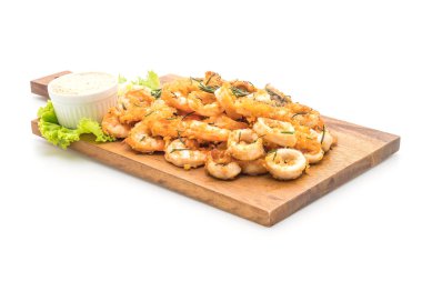 Beyaz arka plan üzerinde izole soslu kızarmış deniz ürünleri (mürekkep, karides, midye)