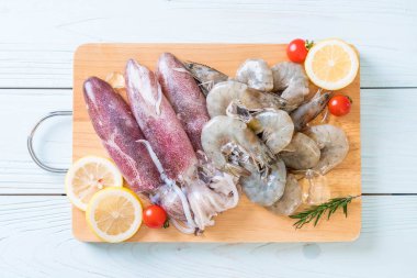 taze deniz ürünleri ham (karides, mürekkep) malzemelerle ahşap tahta üzerinde