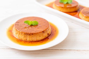 Ev yapımı karamel kremalı puding ahşap arka plan üzerinde