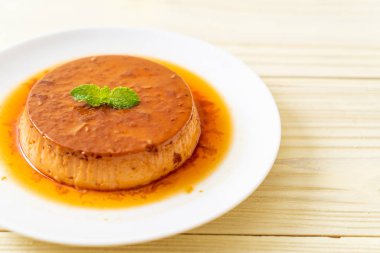 Ev yapımı karamel kremalı puding ahşap arka plan üzerinde