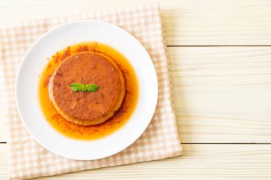 Ev yapımı karamel kremalı puding ahşap arka plan üzerinde