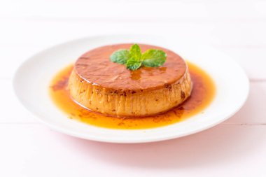 Ev yapımı karamel kremalı puding ahşap arka plan üzerinde