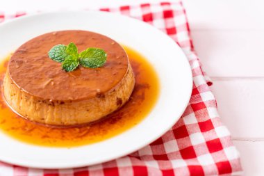 Ev yapımı karamel kremalı puding ahşap arka plan üzerinde